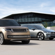 A champaign colored Land Rover Range Rover parked next to a silver Jaguar I-Pace.